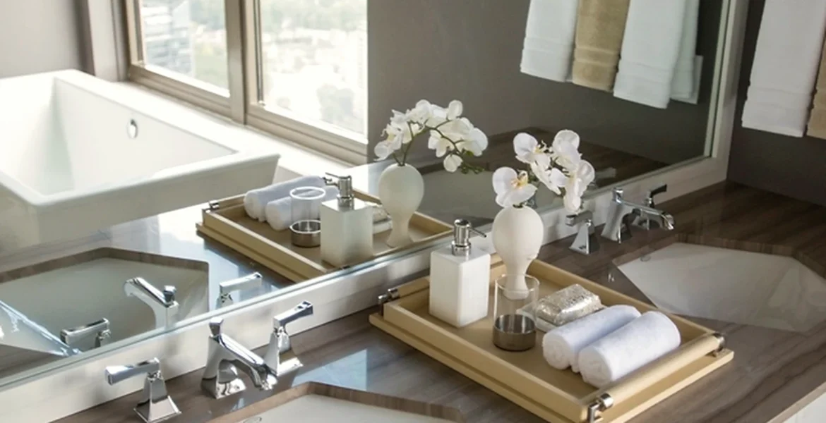 Bathroom vanity area with mirror lighting and practical storage