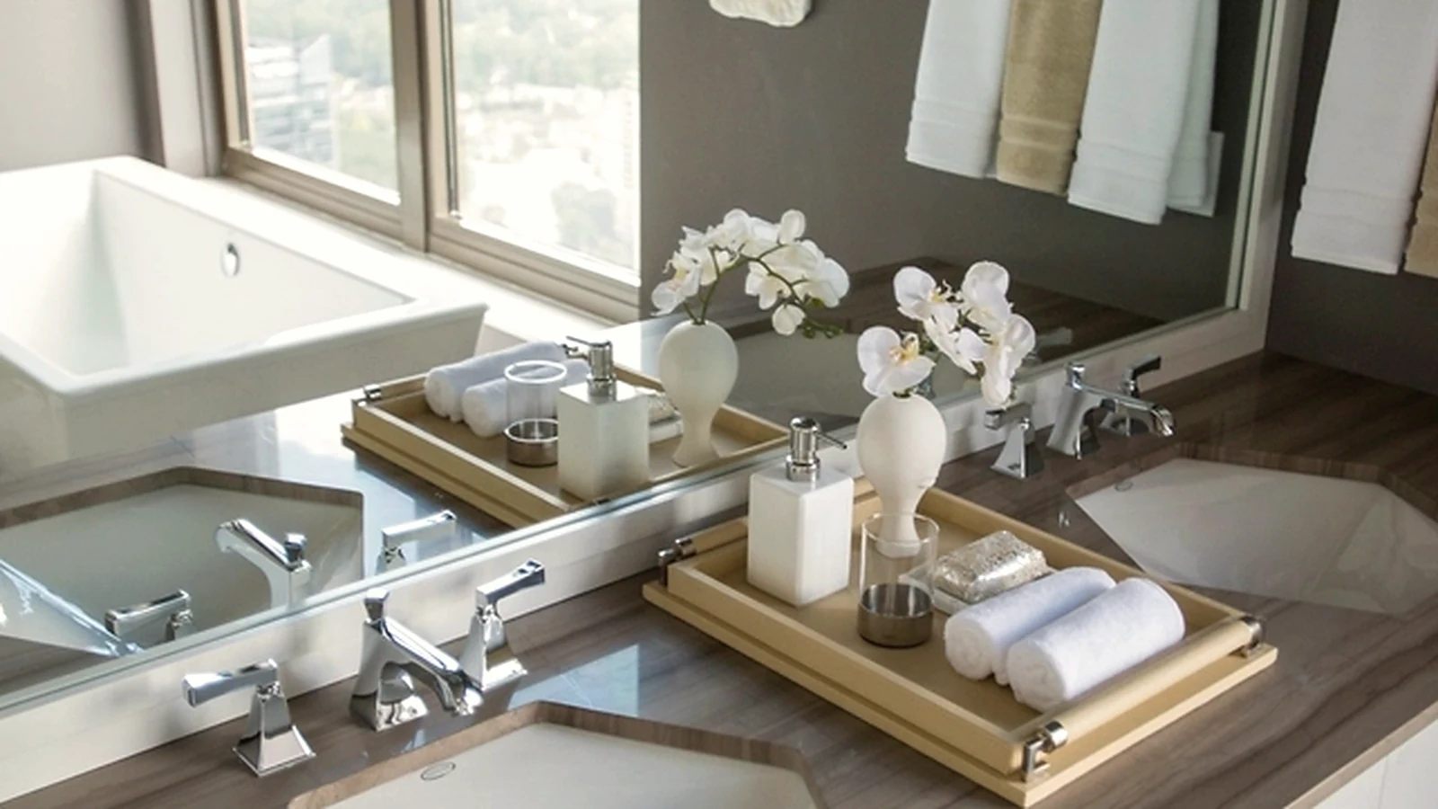 Bathroom vanity area with mirror lighting and practical storage
