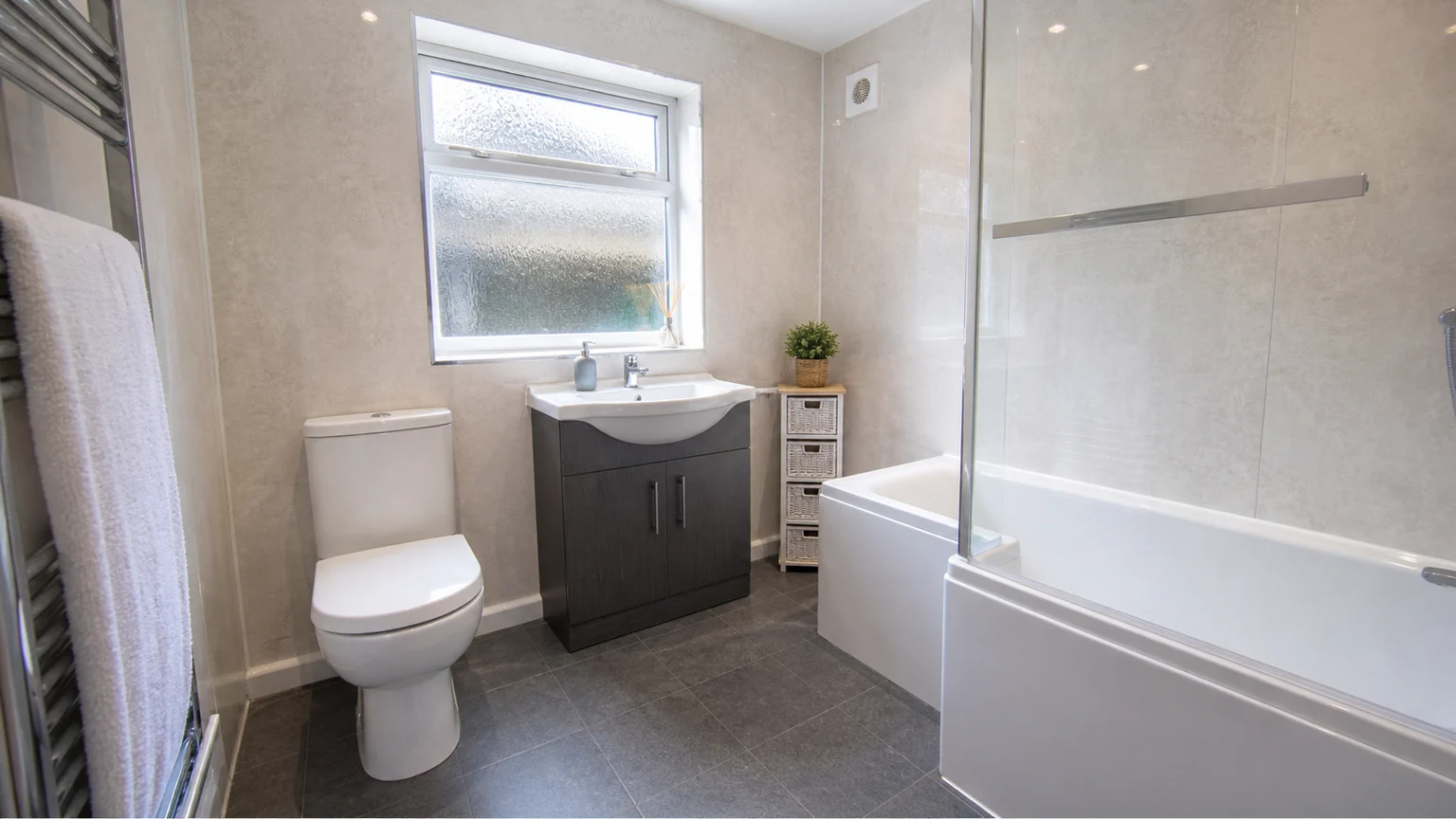 Practical bathroom renovation in Widnes with bath shower screen and wall panels